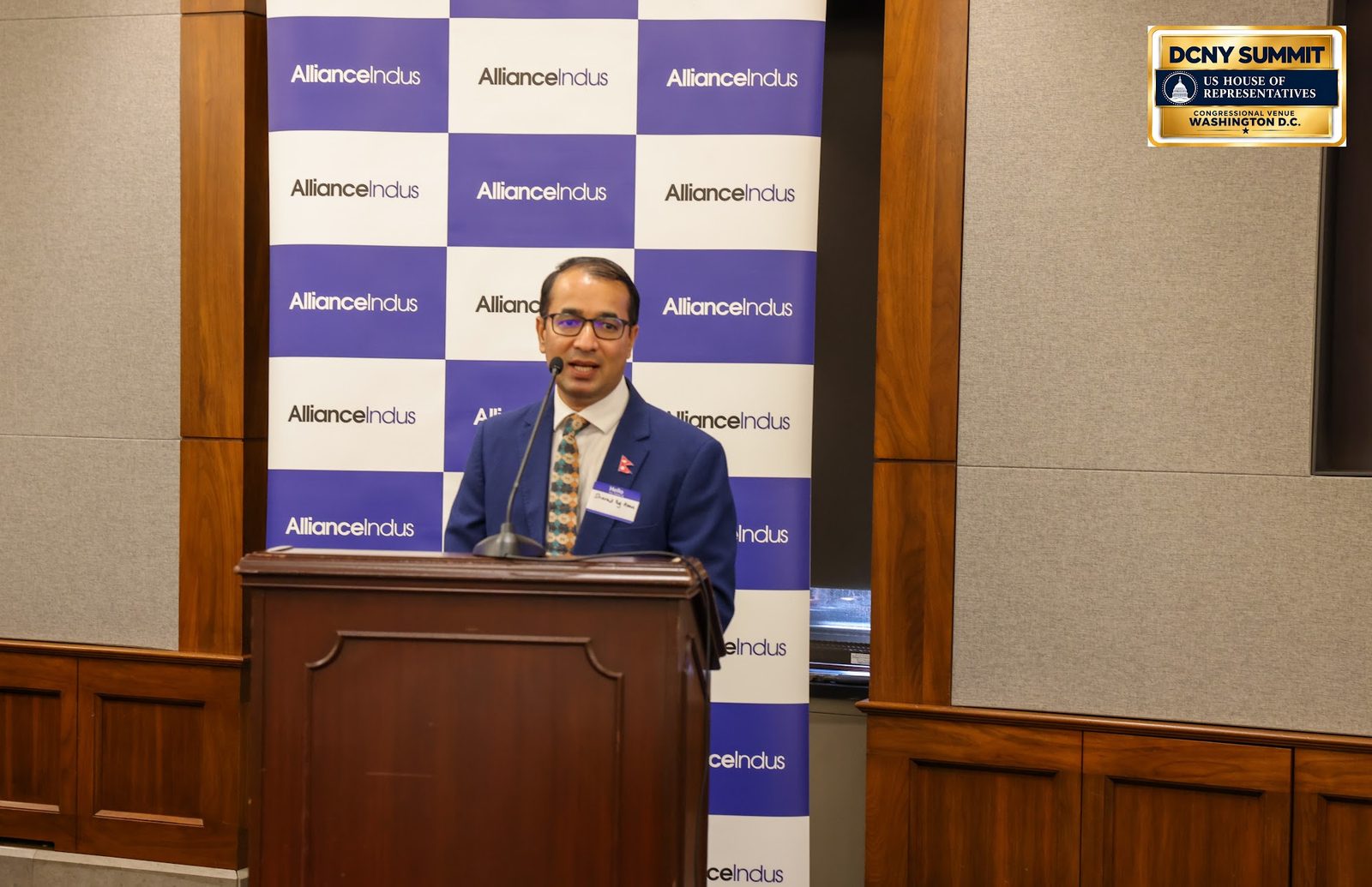 Nepal's ambassador speaks at the podium in front of an AllianceIndus backdrop
