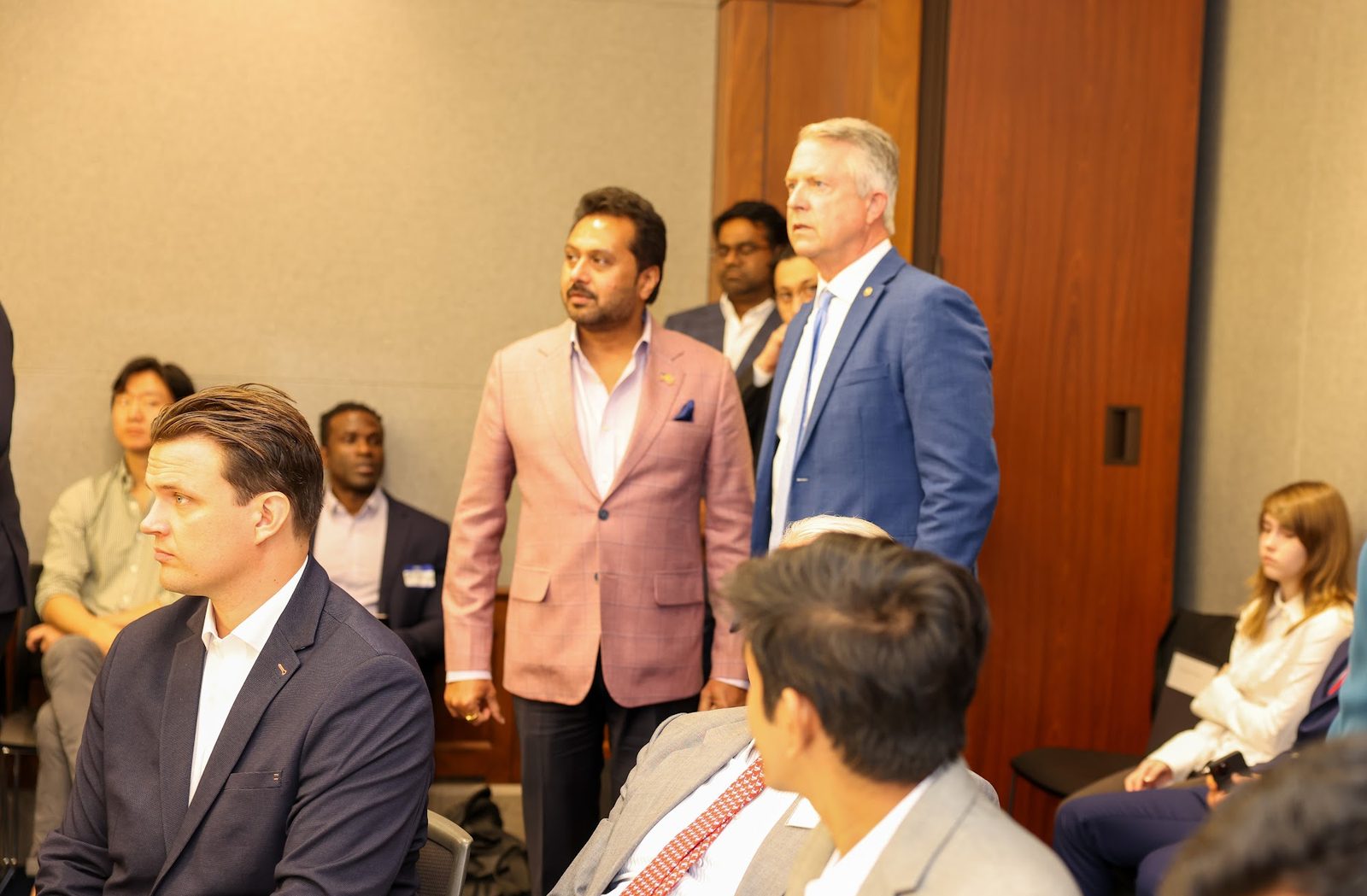 Guests standing and talking at the side of the room