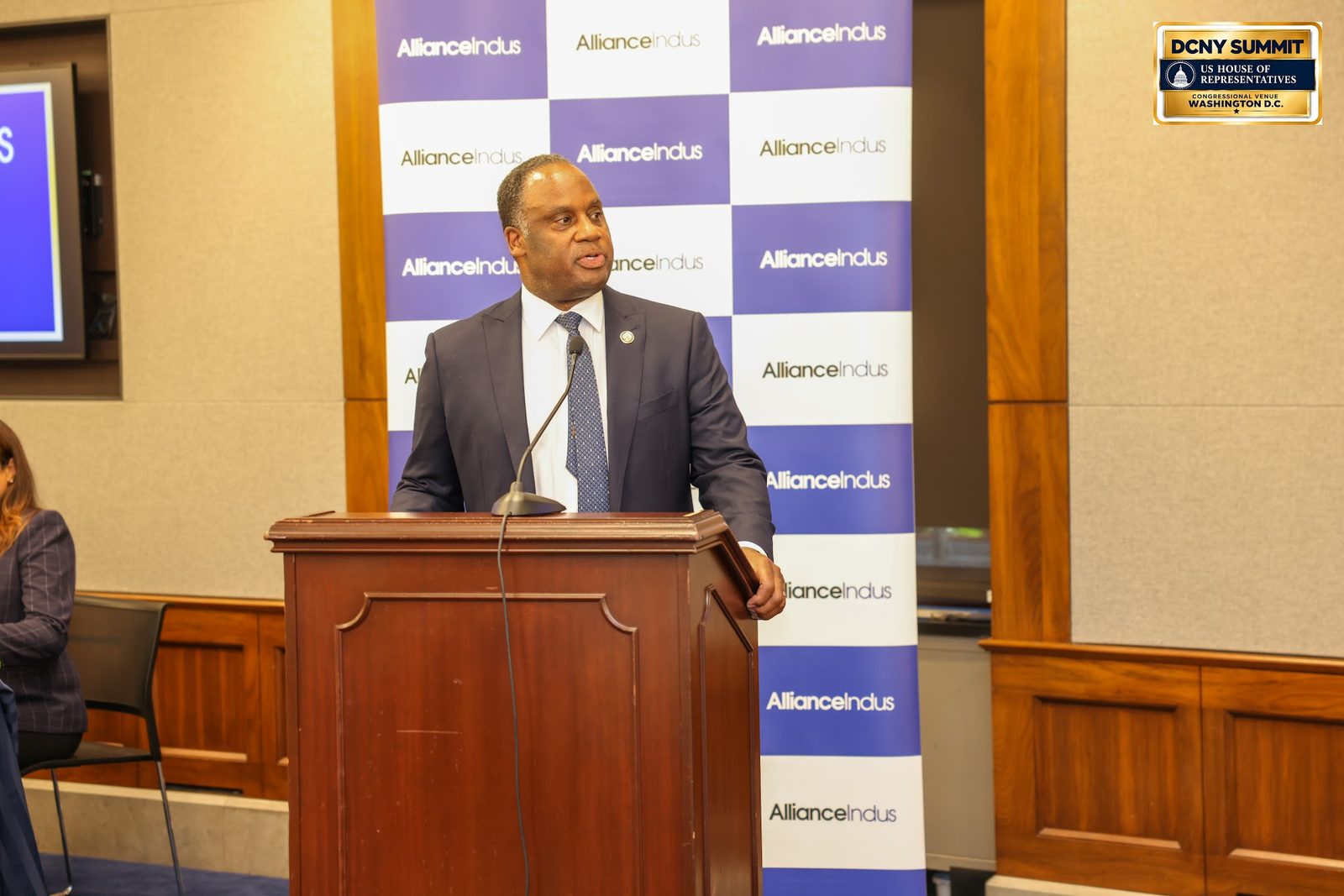 Rep. Jonathan Jackson speaks at the podium in front of an AllianceIndus backdrop