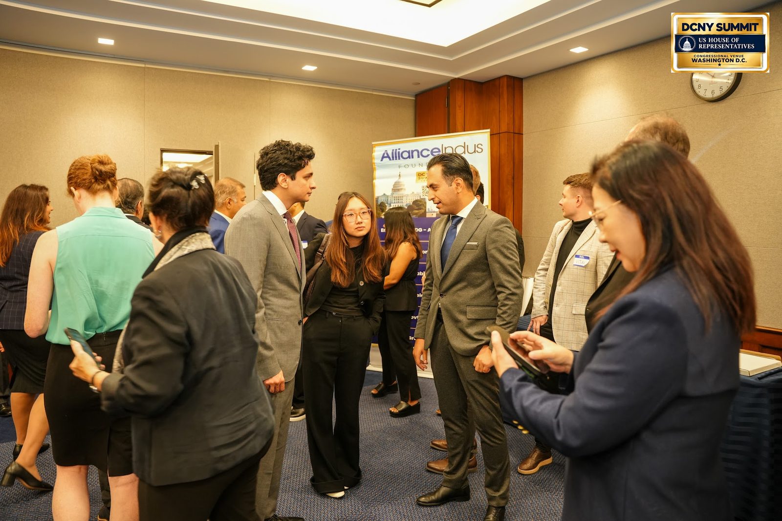 A crowd of guests standing and talking in the conference room