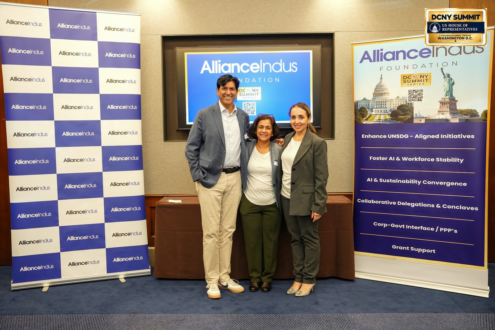 Three guests pose together at the AllianceIndus photo wall