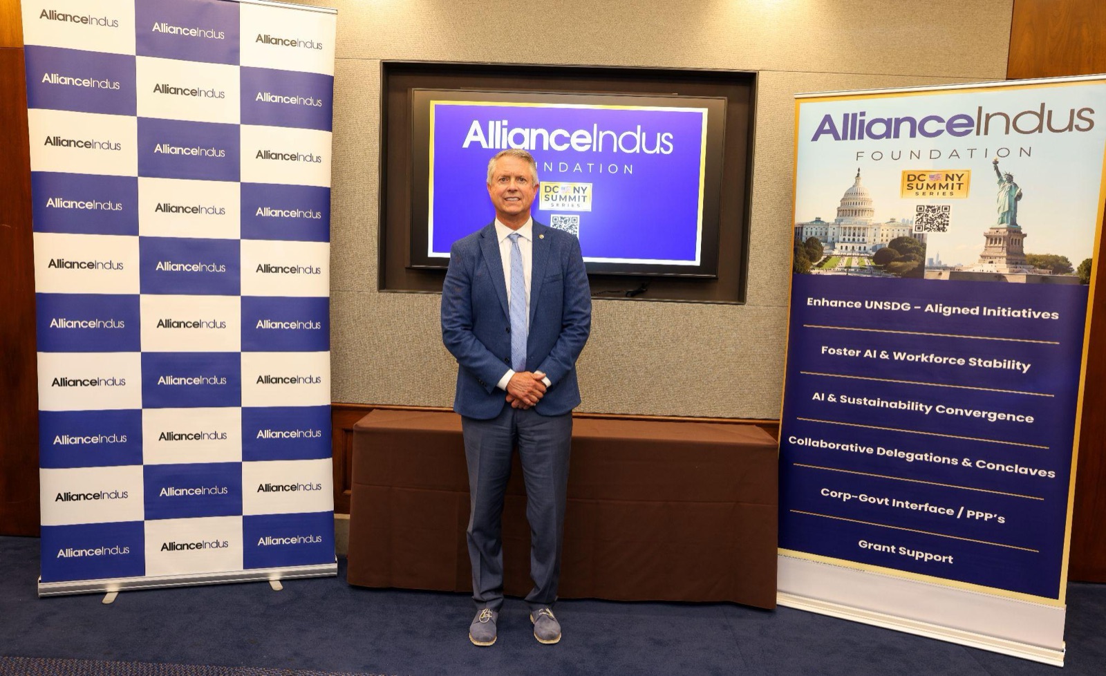 Sen. Roger Marshall standing between an AllianceIndus step-and-repeat backdrop and a banner listing the foundation's focus areas